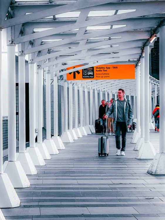 空港到着後、荷物を持ってレンタカー施設へ移動する場面を補完。