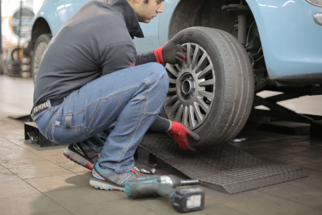 整備工場で車のタイヤを交換する整備士