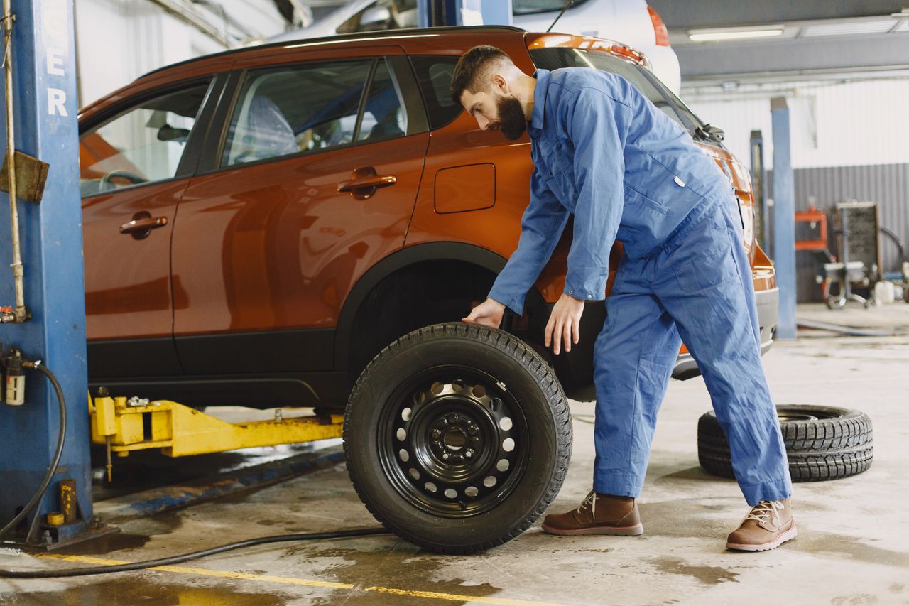 タイヤ交換作業中の整備士と車
